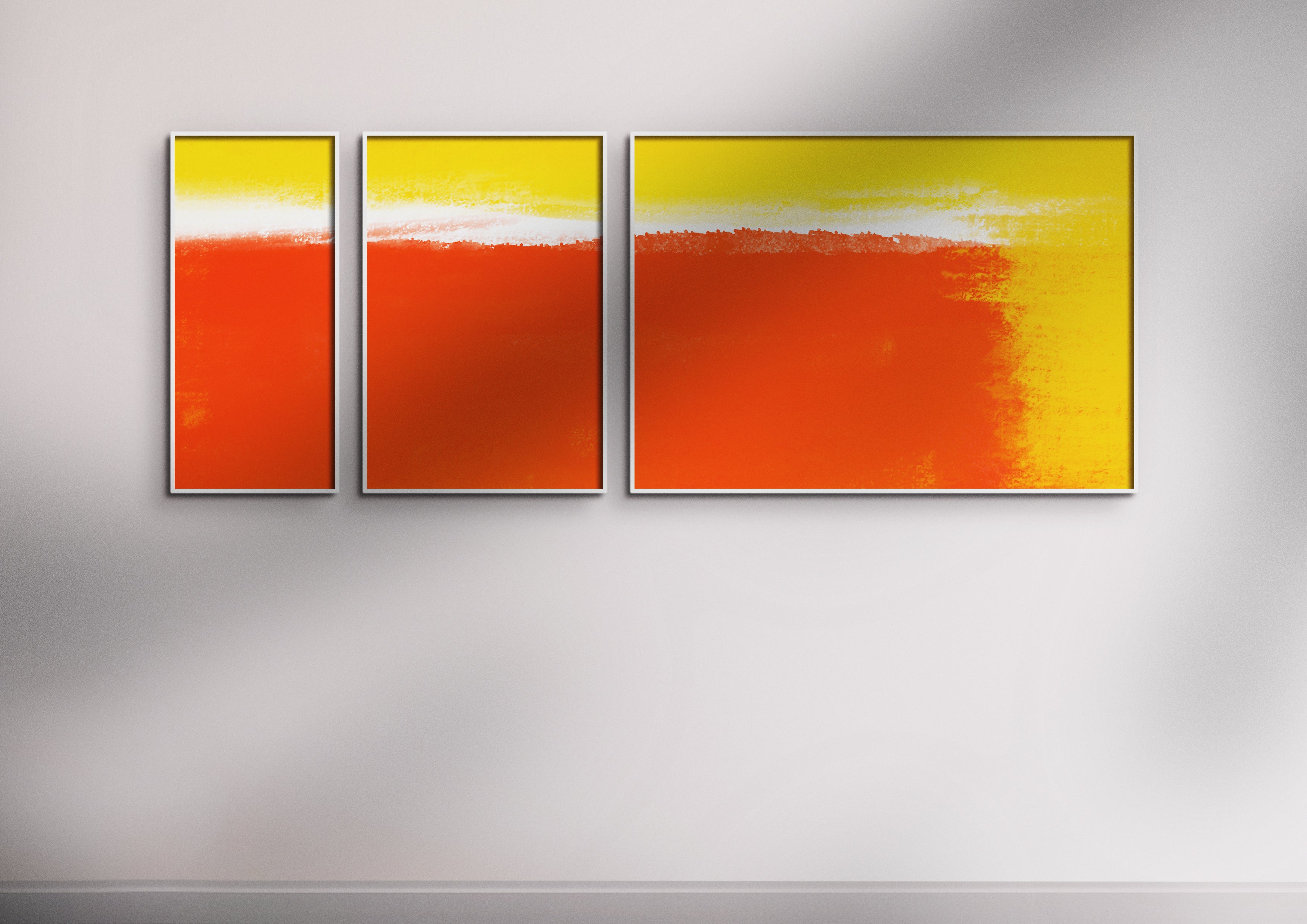 Red Yellow and White Triptych print set in white frames on light grey wall with shadows over it.