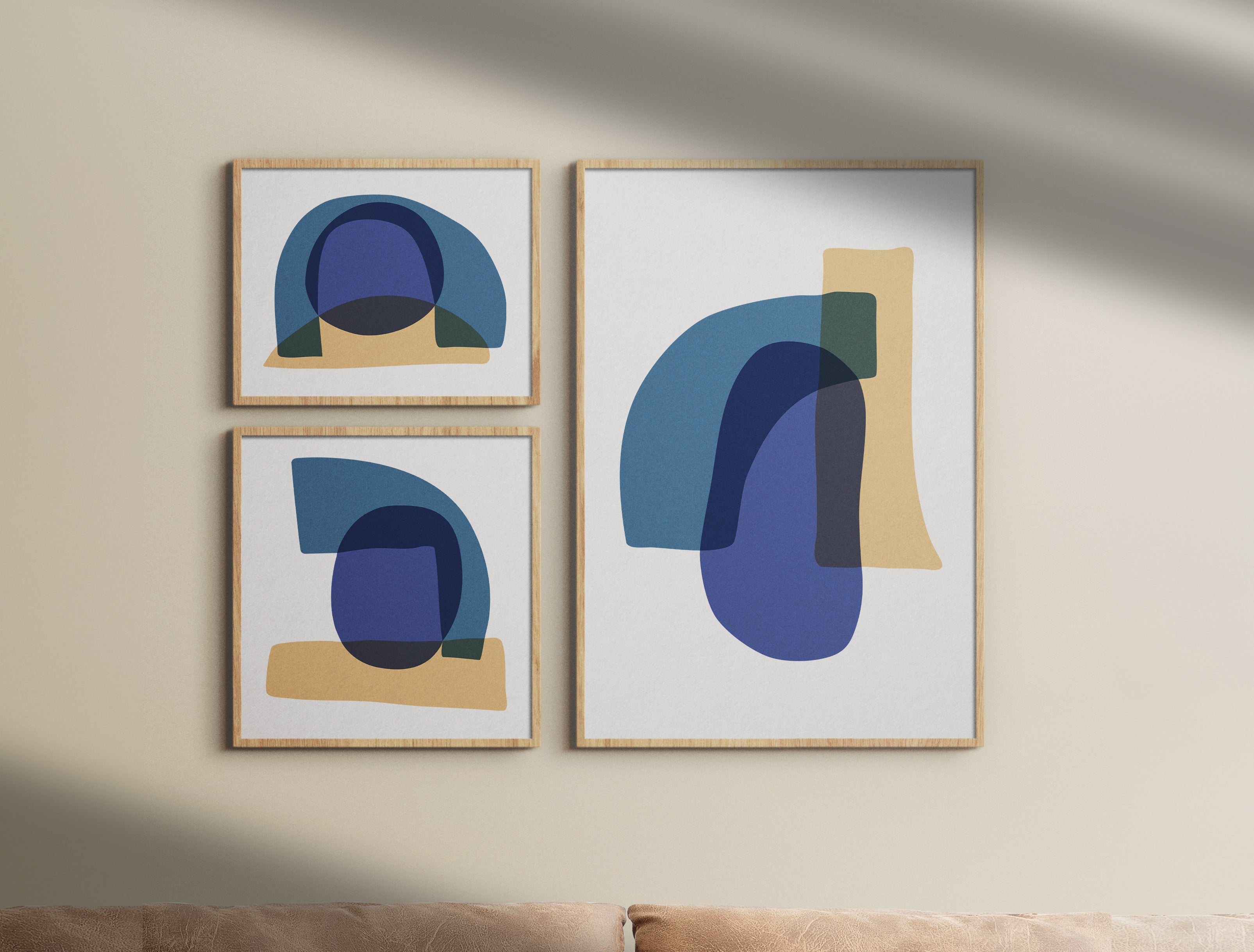 A Study in Blue luxury modern abstract art triptych – museum-quality framed artwork for contemporary interiors. Shown as a framed triptych set hanging on a light beige wall above brown couch.